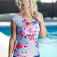 Woman by pool wearing a gray and floral modest swimsuit top