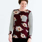 Woman wearing a stripe and floral contrast long sleeve tee with a pocket.