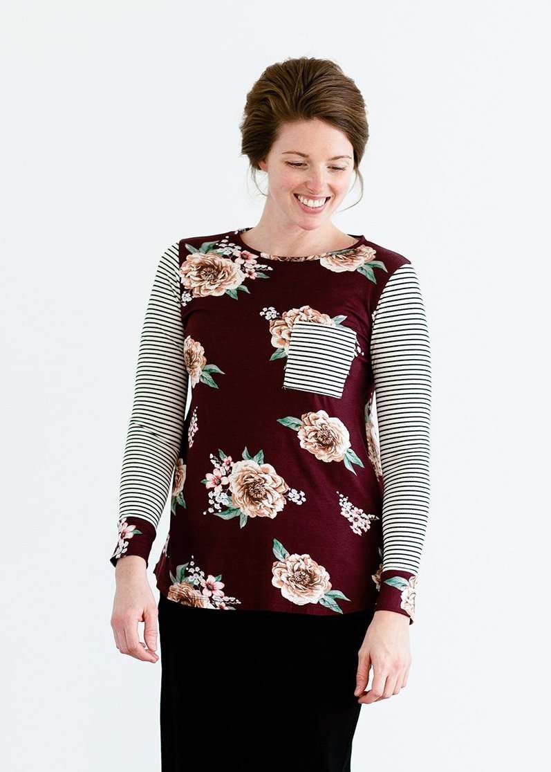 Woman wearing a stripe and floral contrast long sleeve tee with a pocket.