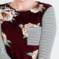 Woman wearing a stripe and floral contrast long sleeve tee with a pocket.