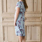 Woman wearing a light blue modest empire waist midi dress with flowers on it