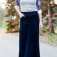 Women wearing a long dark blue denim skirt that is a-line and has flare. This modest skirt is also paired with a floral and gray raglan tee.