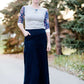 Women wearing a long dark blue denim skirt that is a-line and has flare. This modest skirt is also paired with a floral and gray raglan tee.