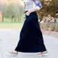 Women wearing a long dark blue denim skirt that is a-line and has flare. This modest skirt is also paired with a floral and gray raglan tee.