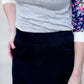 Women wearing a long dark blue denim skirt that is a-line and has flare. This modest skirt is also paired with a floral and gray raglan tee.