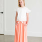 Girl wearing a modest ivory colored tie front top with flutter sleeves