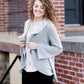 This woman is wearing a tri-blend fleece jacket that is heather gray and has a drape front and shawl collar. 