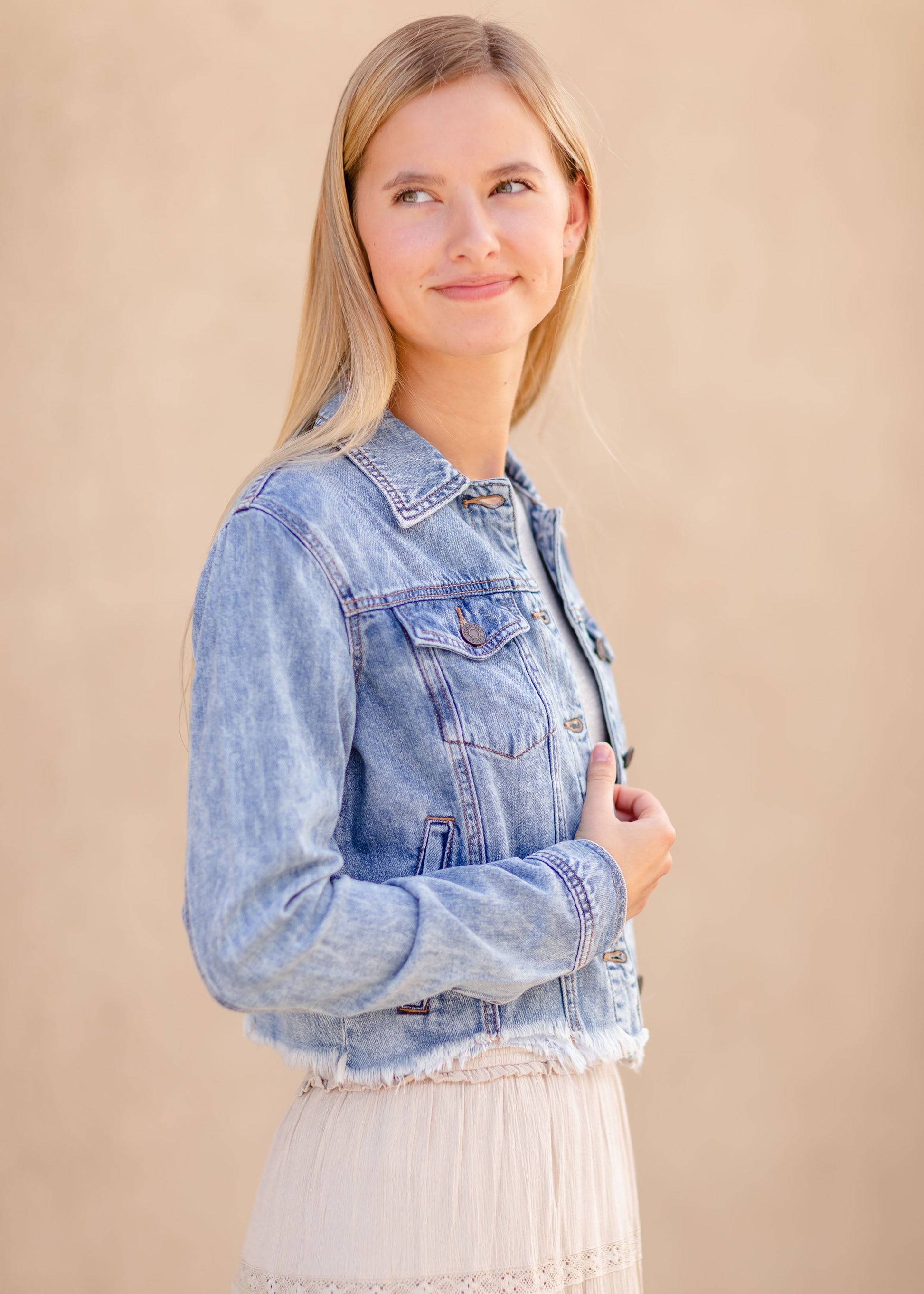 Frayed Light Wash Denim Jean Jacket with brass front buttons, a classic collar and a frayed hem.