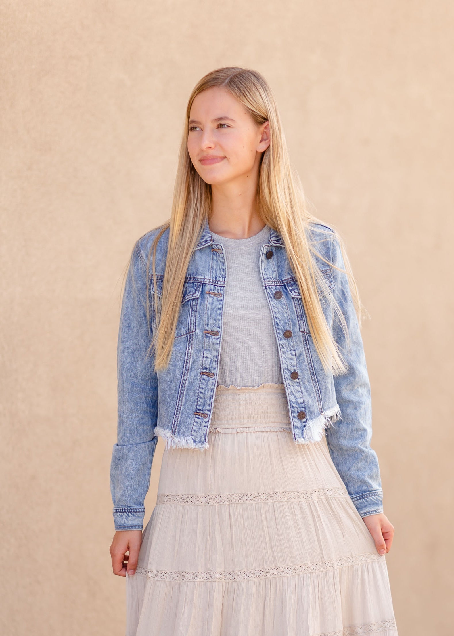 Frayed Light Wash Denim Jean Jacket with brass front buttons, a classic collar and a frayed hem.