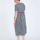 woman wearing a navy and white gingham print midi dress