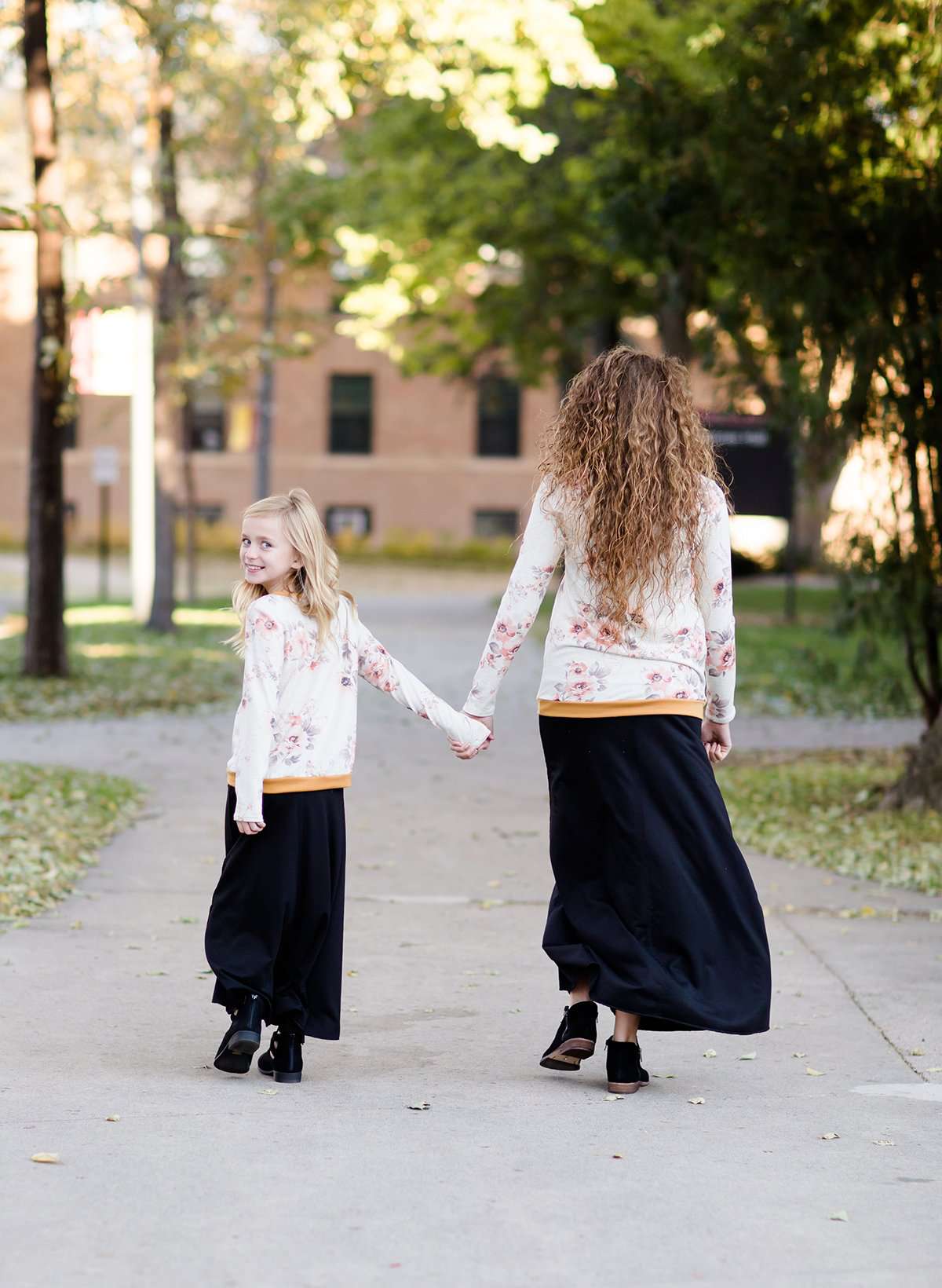 Woman and daughter wearing a blush floral modest sweatshirt with thumbholes that is lined with a mustard trim