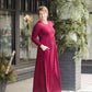 Woman wearing a wine colored maxi dress made of a hacci material standing outside of Inherit Clothing Company