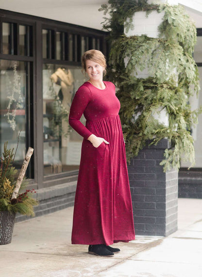 Woman wearing a wine colored maxi dress made of a hacci material standing outside of Inherit Clothing Company
