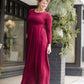 Woman wearing a wine colored maxi dress made of a hacci material standing outside of Inherit Clothing Company