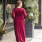 Woman wearing a wine colored maxi dress made of a hacci material standing outside of Inherit Clothing Company