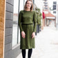 Woman wearing a olive colored hacci midi dress with a elastic waist and paired with black sole society boots