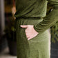 Woman wearing a olive colored hacci midi dress with a elastic waist and paired with black sole society boots