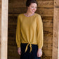 Woman wearing a mustard tie front top with back buttons