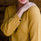 Woman wearing a mustard tie front top with back buttons