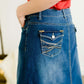 A-line long denim skirt with no slit and a raw edge hem.