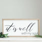 Wood Frame Signboard with the words" It is well with my soul" printed on it in black script font.