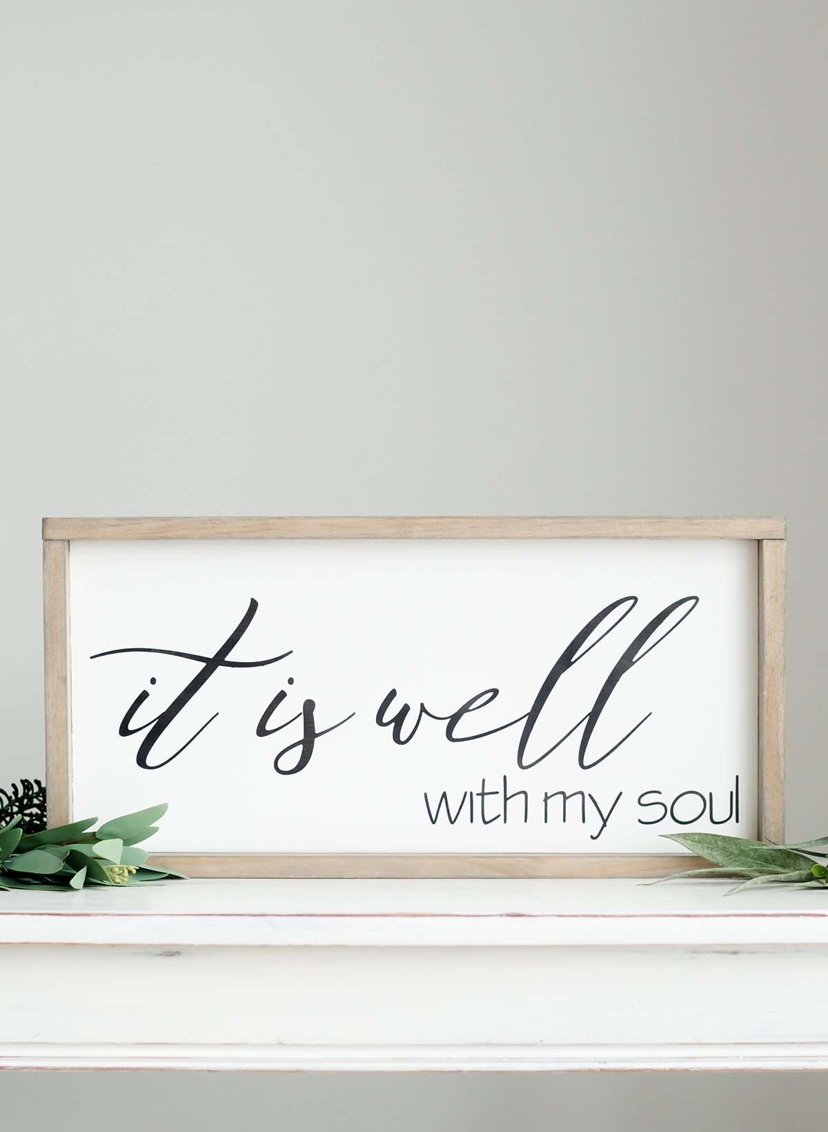 Wood Frame Signboard with the words" It is well with my soul" printed on it in black script font.