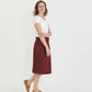 Woman wearing a colored, denim-like skirt with a elastic waistband. This is a modest skirt that falls below the knee. It comes in Burgundy, olive, khaki, black and navy. It is also paired with a white v-neck t-shirt.