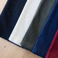 Woman wearing a colored, denim-like skirt with a elastic waistband. This is a modest skirt that falls below the knee. It comes in Burgundy, olive, khaki, black and navy. It is also paired with a white v-neck t-shirt.