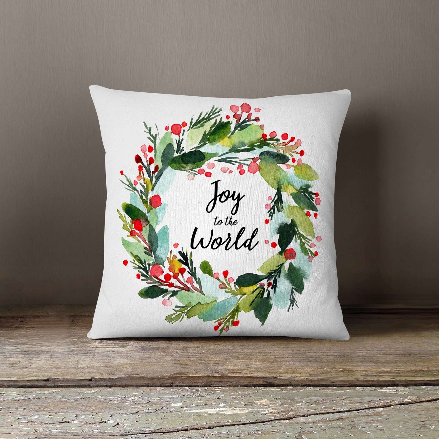 Red, Green and blue holiday wreath print on a throw pillow that says Joy to the World.