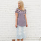 Young lady wearing a light denim below the knee jean skirt.