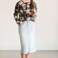 Young lady wearing a light denim below the knee jean skirt.