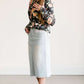 Young lady wearing a light denim below the knee jean skirt.
