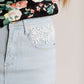 Young lady wearing a light denim below the knee jean skirt.