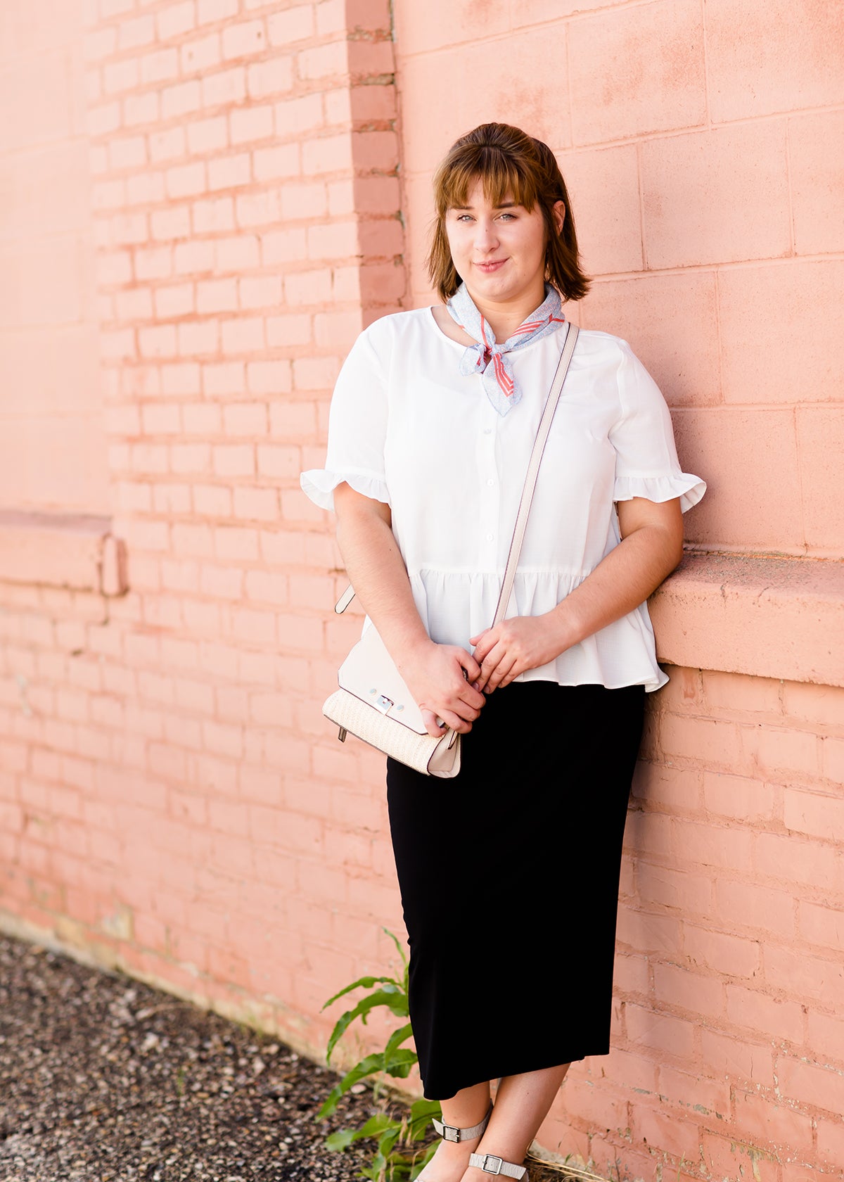 Woman wearing a straight style, ultra soft versatile black midi skirt.