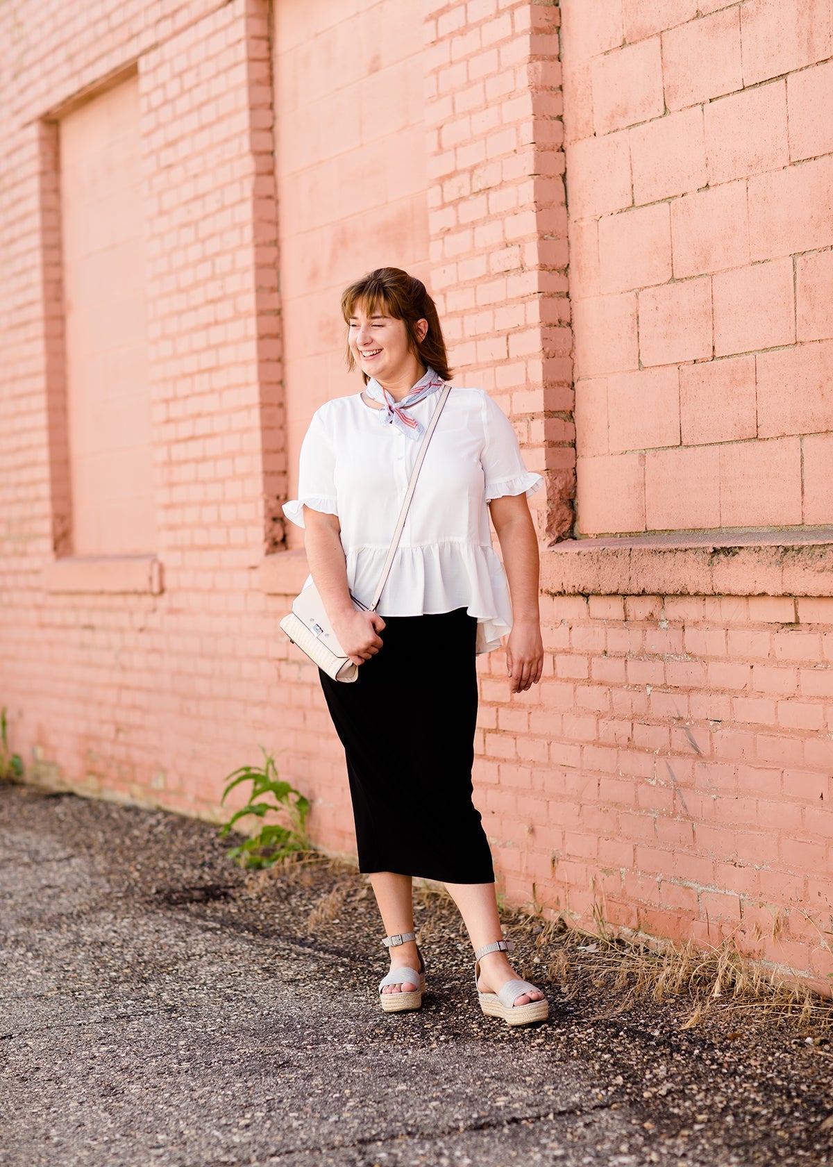 Woman wearing a straight style, ultra soft versatile black midi skirt.