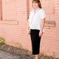 Woman wearing a straight style, ultra soft versatile black midi skirt.