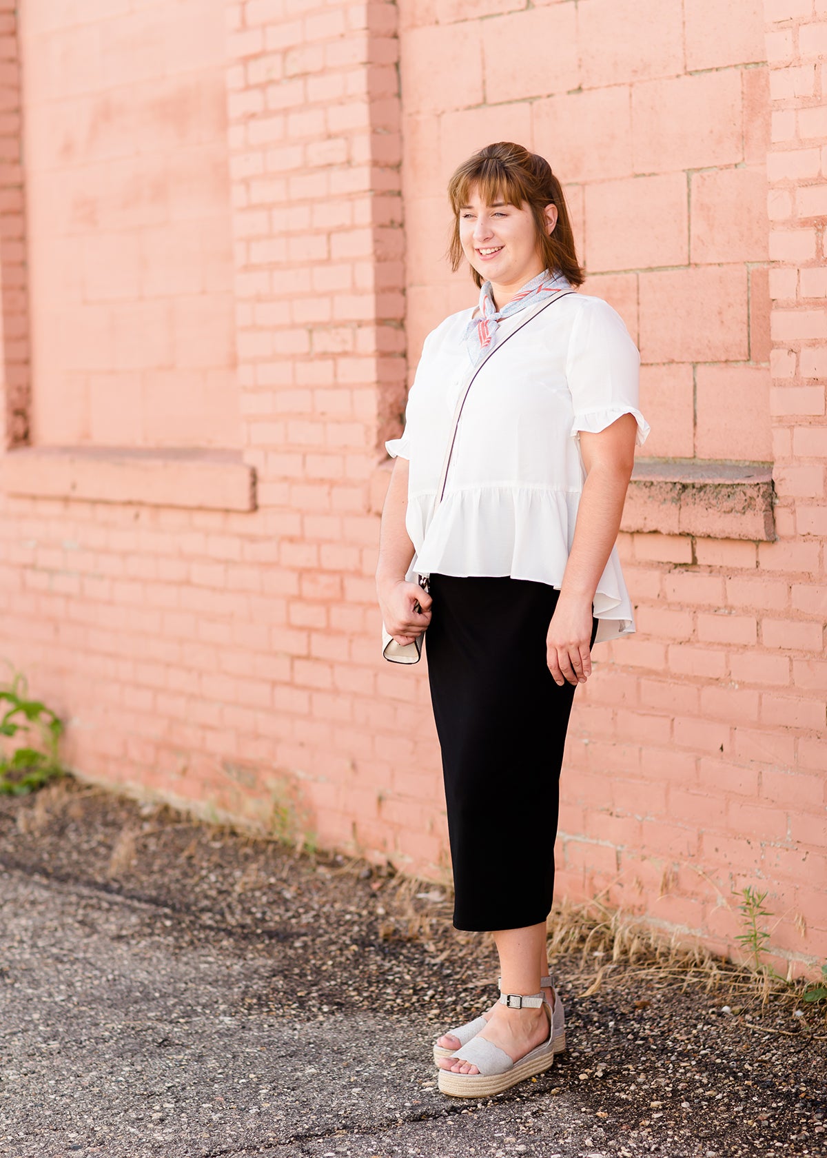 Woman wearing a straight style, ultra soft versatile black midi skirt.