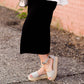 Woman wearing a straight style, ultra soft versatile black midi skirt.