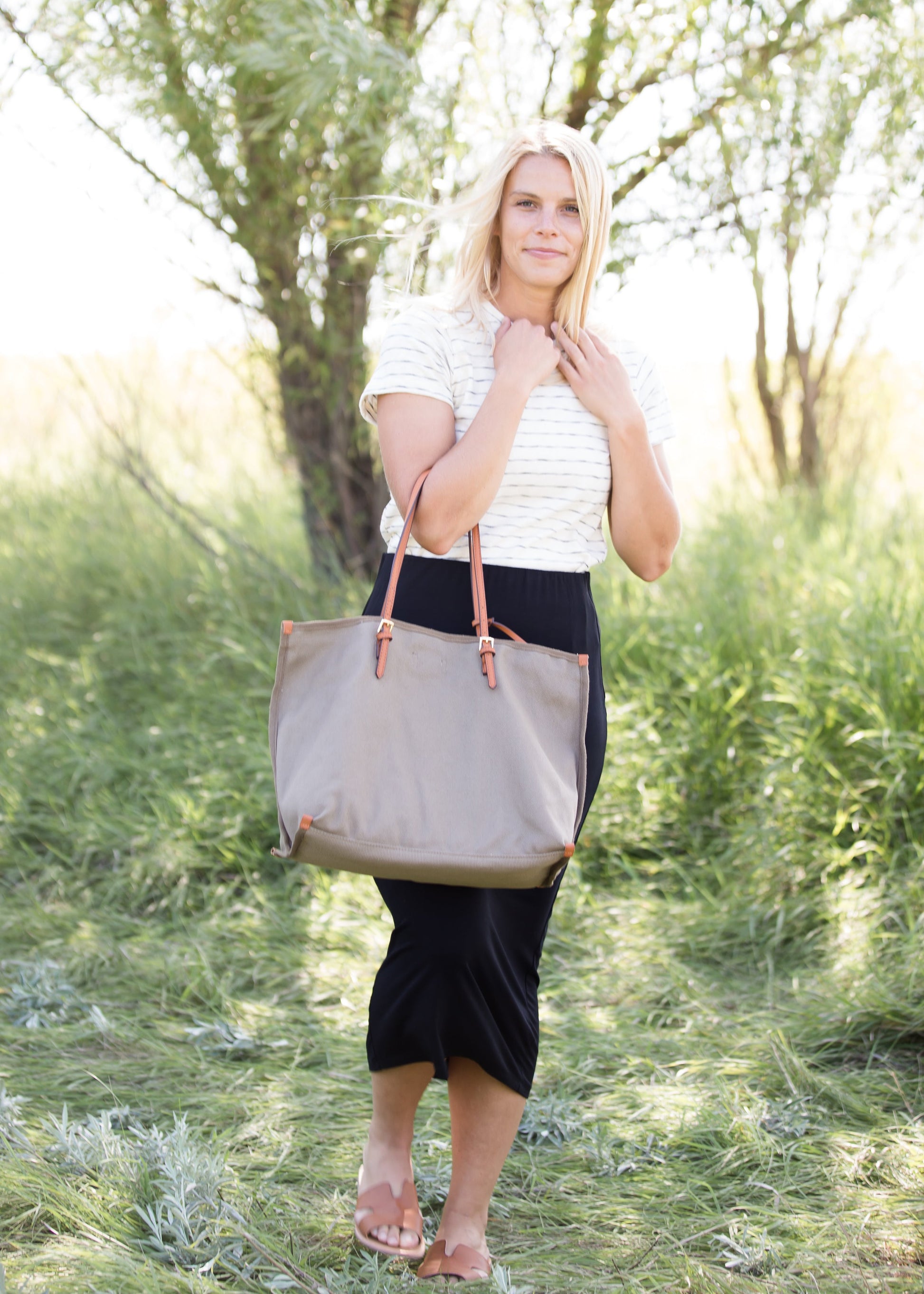 Woman wearing a straight style, ultra soft versatile black midi skirt.