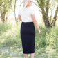 Woman wearing a straight style, ultra soft versatile black midi skirt.