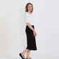 Woman wearing a straight style, ultra soft versatile black midi skirt.