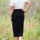 Woman wearing a straight style, ultra soft versatile black midi skirt.