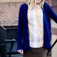 Young woman wearing a modest navy open front cardigan with front pockets and buttons over a mustard striped blouse