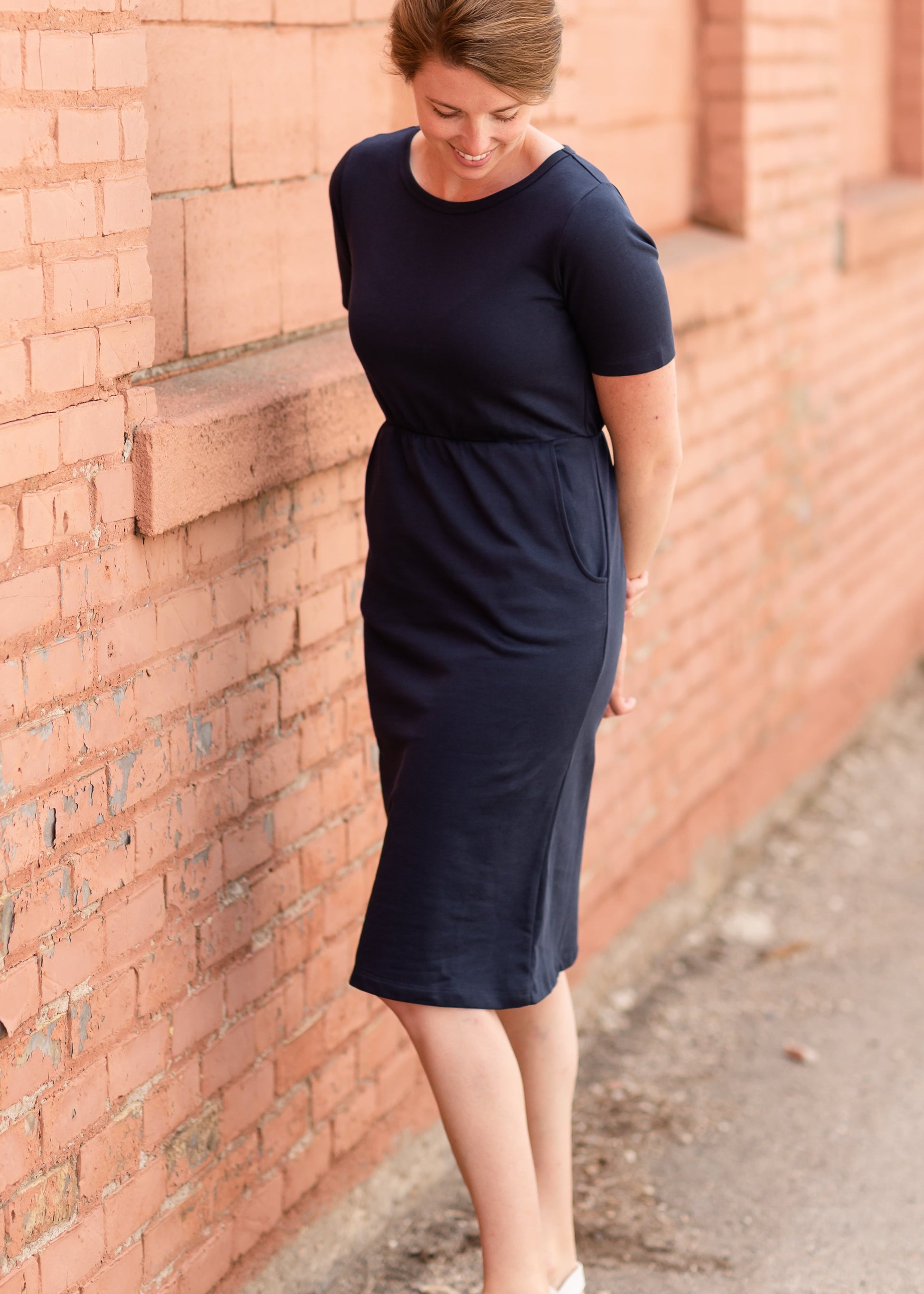 Meet Kristen. This Short sleeve Midi Dress was designed in-house and definitely isn't your typical cotton midi dress! This classic style is crafted with quality fabrics and needs no slip. The elastic waist and longer, short sleeves are extremely flattering and feminine. You will also love the placement of the two front pockets as well, this small patch style pocket hits just right!