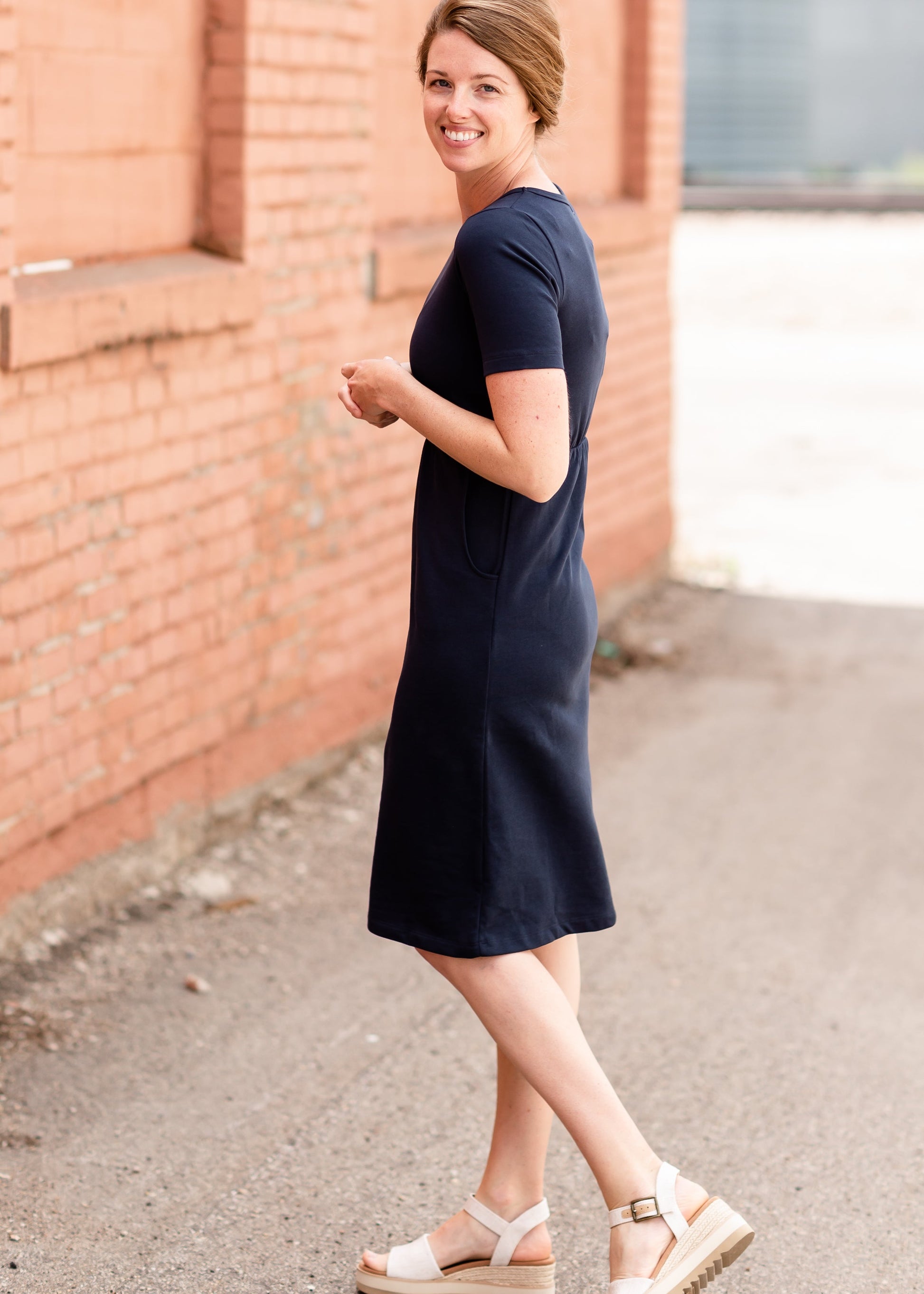 Meet Kristen. This Short sleeve Midi Dress was designed in-house and definitely isn't your typical cotton midi dress! This classic style is crafted with quality fabrics and needs no slip. The elastic waist and longer, short sleeves are extremely flattering and feminine. You will also love the placement of the two front pockets as well, this small patch style pocket hits just right!