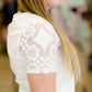 woman wearing a modest white v-neck tee shirt with feminine lace detail on sleeves
