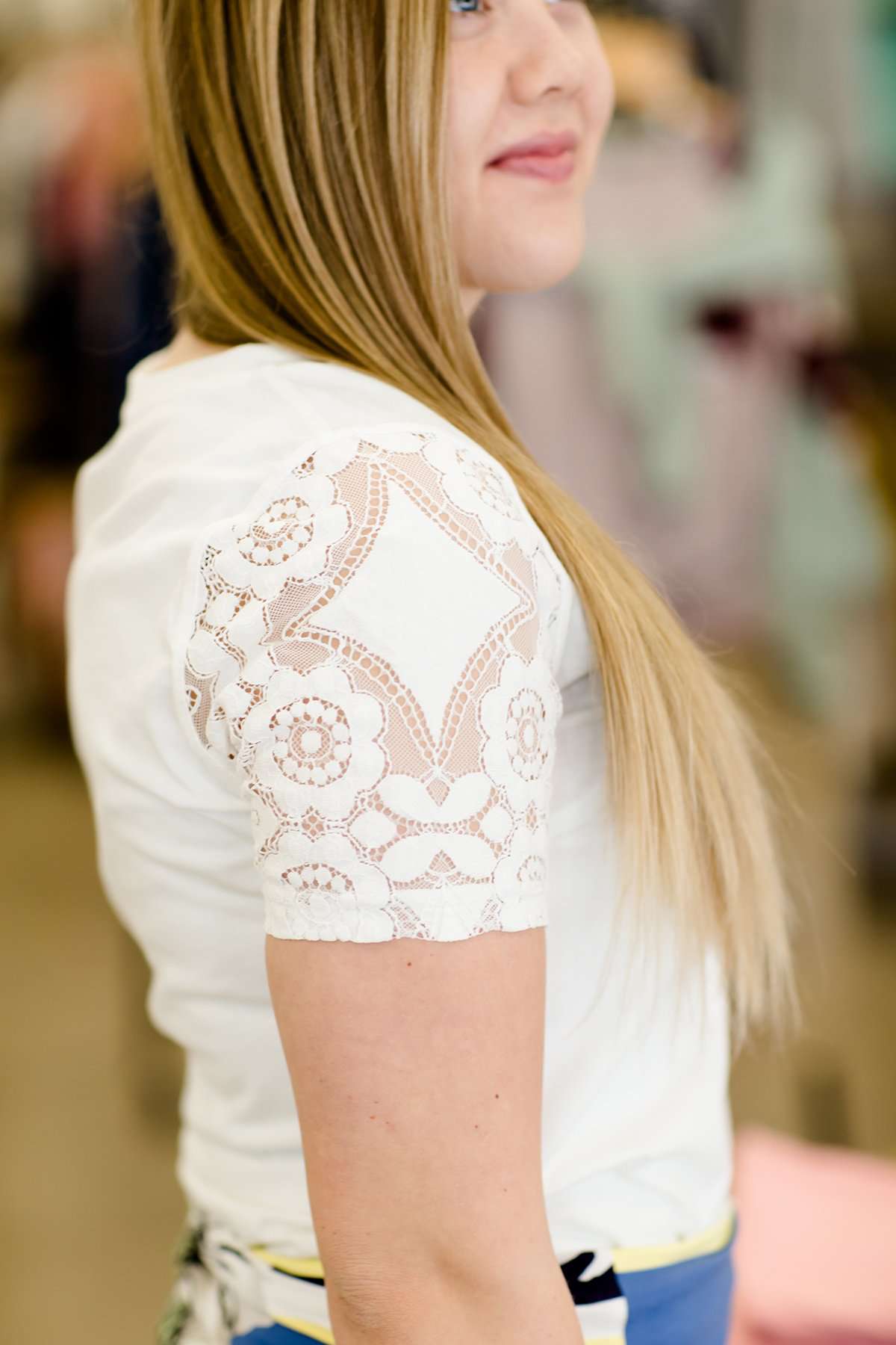 woman wearing a modest white v-neck tee shirt with feminine lace detail on sleeves