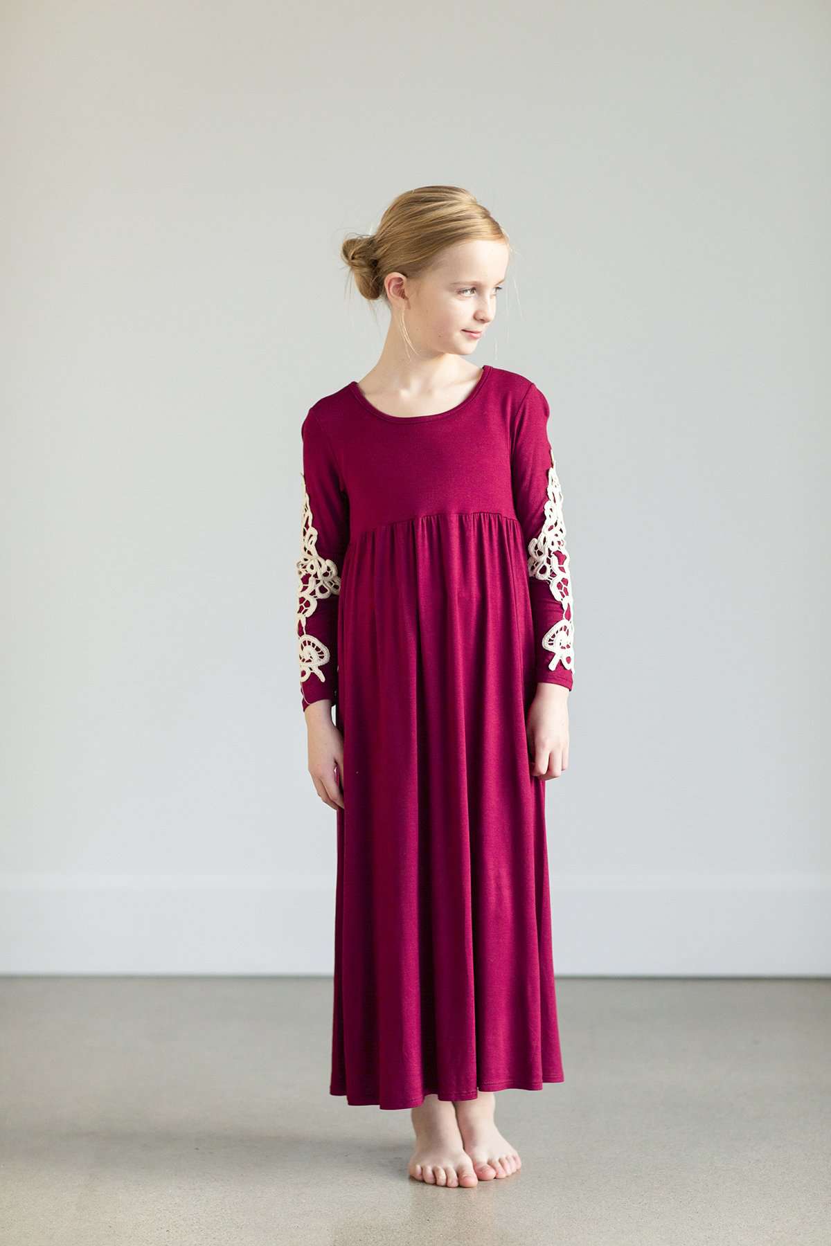 Young girl wearing a burgandy maxi dress with crochet detail.