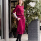 Woman wearing a burgandy and lace midi dress with black tights and sole society back boots. She is standing outside of Inherit Clothing Company.