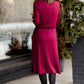 Woman wearing a burgandy and lace midi dress with black tights and sole society back boots. She is standing outside of Inherit Clothing Company.